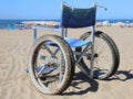 Wheelchair on the beach sand near the sea