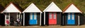 Wheelchair and colourful beach huts with blue and red doors in a row traditional English structure panorama Royalty Free Stock Photo