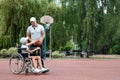 Wheelchair concept, disabled child, father and son, full life, paralyzed. A disabled son in a wheelchair plays with his father on