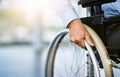 Wheelchair, disability and man hand holding wheel in a hospital for healthcare. Disabled, mobility problem and male