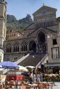 AMALFI, ITALIA, 1980 - A wheelchair with horse passes between the tourists and the tables of a bar in front of the staircase of