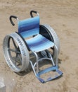 wheelchair with large aluminum wheels on the sand of the beach