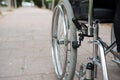 Wheelchair on the outside, in a park on a brick floor