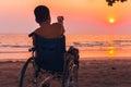 Wheelchair on the sea beach with sunset on travel time in holiday family and learning about nature around the sea Royalty Free Stock Photo