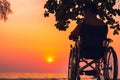 Wheelchair on the sea beach with sunset on travel time in holiday family and learning about nature around the sea Royalty Free Stock Photo