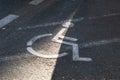 Wheelchair sign on an asphalted parking lot indicating reserved place for physically disabled people Royalty Free Stock Photo