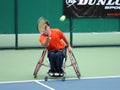 wheelchair tennis player during a tennis championship match, taking a shot