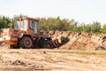 A wheeled dozer collects soil into a bucket in a quarry. Royalty Free Stock Photo