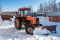 Wheeled snow plow tractor with blade in winter Royalty Free Stock Photo