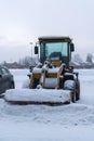 Wheeled snow plow tractor with a bucket