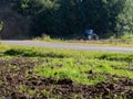 A wheeled tractor cultivates the soil in areas adjacent to the forest area for fire protection of forest plantations.