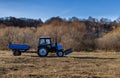 wheeled tractor with a trailer driving across the field Royalty Free Stock Photo