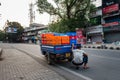 A 3-wheeler milk loader breaks down on the road as the driver inspects underneath. Capturing a rural transport mishap and vehicle