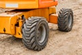 Wheels of industrial lifting transport tire truck against the background of sand at a construction site Royalty Free Stock Photo