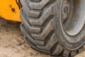 Wheels of industrial lifting transport tire truck against the background of sand at a construction site Royalty Free Stock Photo