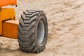 Wheels of industrial lifting transport tire truck against the background of sand at a construction site Royalty Free Stock Photo