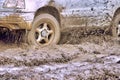 Wheels of the offroader are slipping in the mud and splashing slush on the car Royalty Free Stock Photo