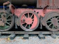 wheels on an old rusting abandoned steam locomotive with red and