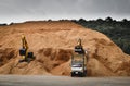 10 wheels truck is loading wood chip at stock piles ready to load to vessel for export. Paper and biomass industries. Royalty Free Stock Photo