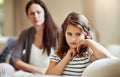 This is where discipline starts. a young girl being reprimanded by her mother at home.