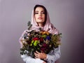 Where flowers bloom so does her beauty. Studio portrait of a confident young woman wearing a colorful head scarf and Royalty Free Stock Photo