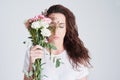 Where flowers bloom, so does hope. Studio shot of a beautiful young woman holding a bouquet of flowers against a grey Royalty Free Stock Photo