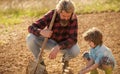 Where food comes from. Teaching son growing plants. Planting plants. Works in field. Father farmer instruct baby how to