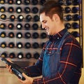 This is where the money lies. a handsome young man choosing a bottle of wine in a restaurant. Royalty Free Stock Photo