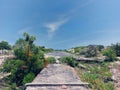 Where the road ends and meet with bush, grass and tree and a concrete structure of a sewage Royalty Free Stock Photo