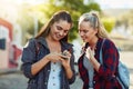 Where should we go now, what does the app say. two beautiful female friends using a cellphone together in the city. Royalty Free Stock Photo