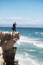 Where to go from here. Confused businessman standing on the edge of a cliff overlooking the ocean. Royalty Free Stock Photo