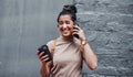 Where are you. an attractive teenage girl standing alone and using her cellphone while holding a cup of coffee. Royalty Free Stock Photo