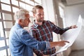 Is this where you want the window. two male architects discussing blueprints while standing indoors. Royalty Free Stock Photo