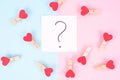 Where is your love concept. Photo of little red heart lying around white paper with question mark