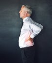 Wheres a massage when you need one. Studio shot of a mature man experiencing muscular strain.