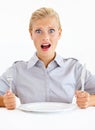 Wheres my food. Dismayed young woman sitting in front of an empty plate while holding her knife and fork.