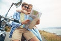 Wheres our next stop. a couple using a map while out on a road trip.