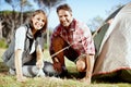 Wheres the peg. Portrait of a young couple setting up their tent.