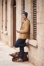 Wheres your next move. a handsome young man sending a text message while leaning against a wall outside. Royalty Free Stock Photo