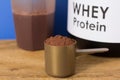 Whey Protein. Close up of scoop with chocolate powder, jar and s Royalty Free Stock Photo