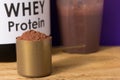 Whey Protein. Close up of scoop with chocolate powder, jar and s Royalty Free Stock Photo