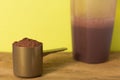 Whey Protein. Close up of scoop with chocolate powder and shaker Royalty Free Stock Photo