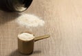 Whey Protein. Dropped black jar and spilled powder. Yellow measuring scoop. Selective focus and wooden table. Royalty Free Stock Photo