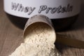 Whey Protein. Dropped scoop with vanilla powder flavour. Wooden Royalty Free Stock Photo