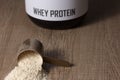 Whey Protein. Dropped scoop with vanilla powder flavour. Wooden Royalty Free Stock Photo