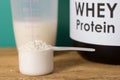 Whey Protein. Front view of scoop with vanilla powder, jar and s Royalty Free Stock Photo