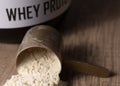 Whey Protein. Golden scoop on wooden background with vanilla pow Royalty Free Stock Photo