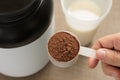 Whey Protein. Perspective of person preparing protein shake. Chocolate flavour. Wooden background