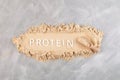 Whey Protein Powder in serving wooden scoop. Pile of pure Protein Powder and word PROTEIN. Food additive often used for healthy