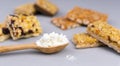 Whey protein powder in spoon and different energy protein bars on grey background. Close-up. Selective focus